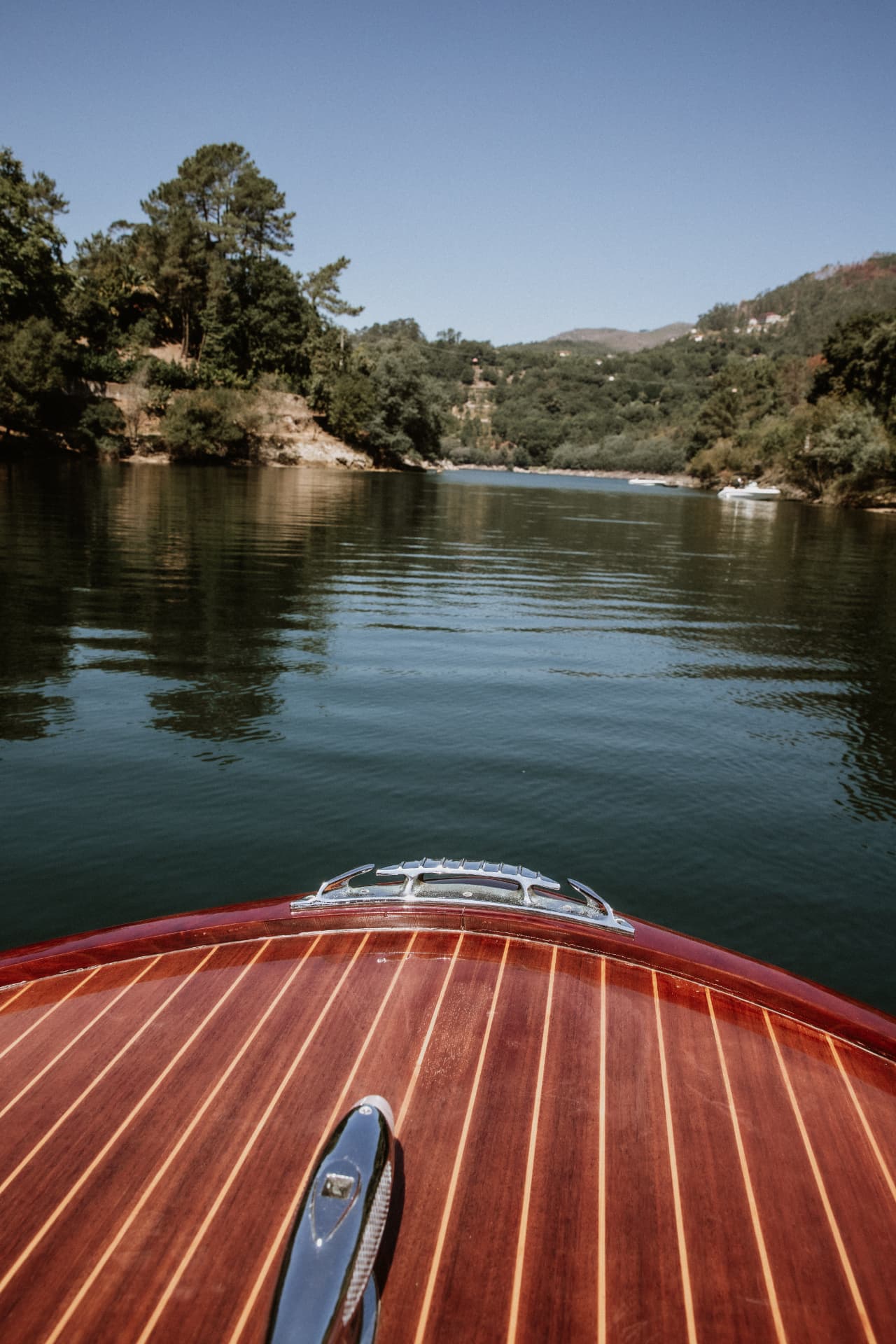 View over the mahogany bow of the Pedrazzini on the river